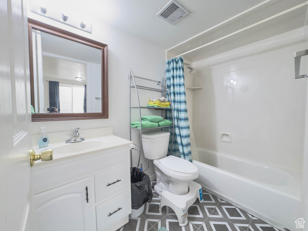 Full bathroom with shower / bath combination with curtain, tile flooring, toilet, and oversized vanity