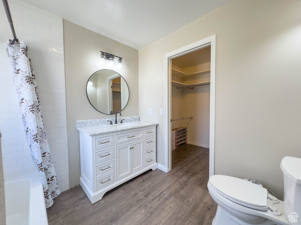 Full bathroom with shower / bath combination with curtain, vanity, toilet, and hardwood / wood-style flooring