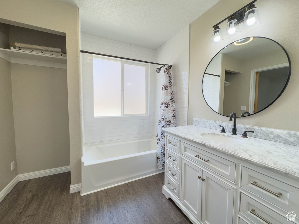 Bathroom featuring hardwood / wood-style floors, vanity, and shower / tub combo with curtain