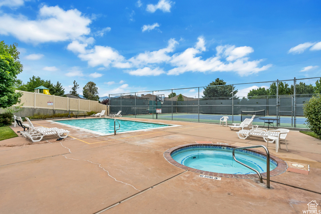 View of swimming pool featuring a patio area and a community hot tub