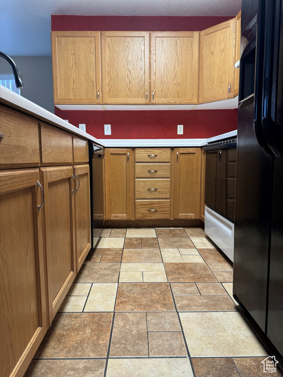Kitchen featuring light tile flooring and black fridge