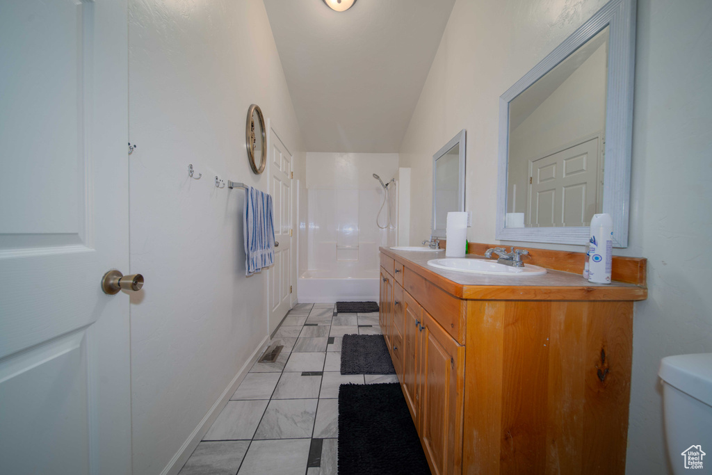 Full bathroom featuring tub / shower combination, tile flooring, lofted ceiling, toilet, and vanity