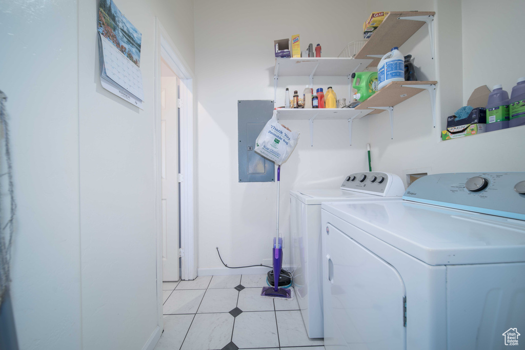 Laundry room featuring light tile floors and washer and clothes dryer