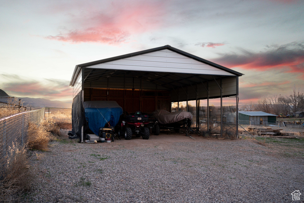 Outdoor structure at dusk featuring a carport
