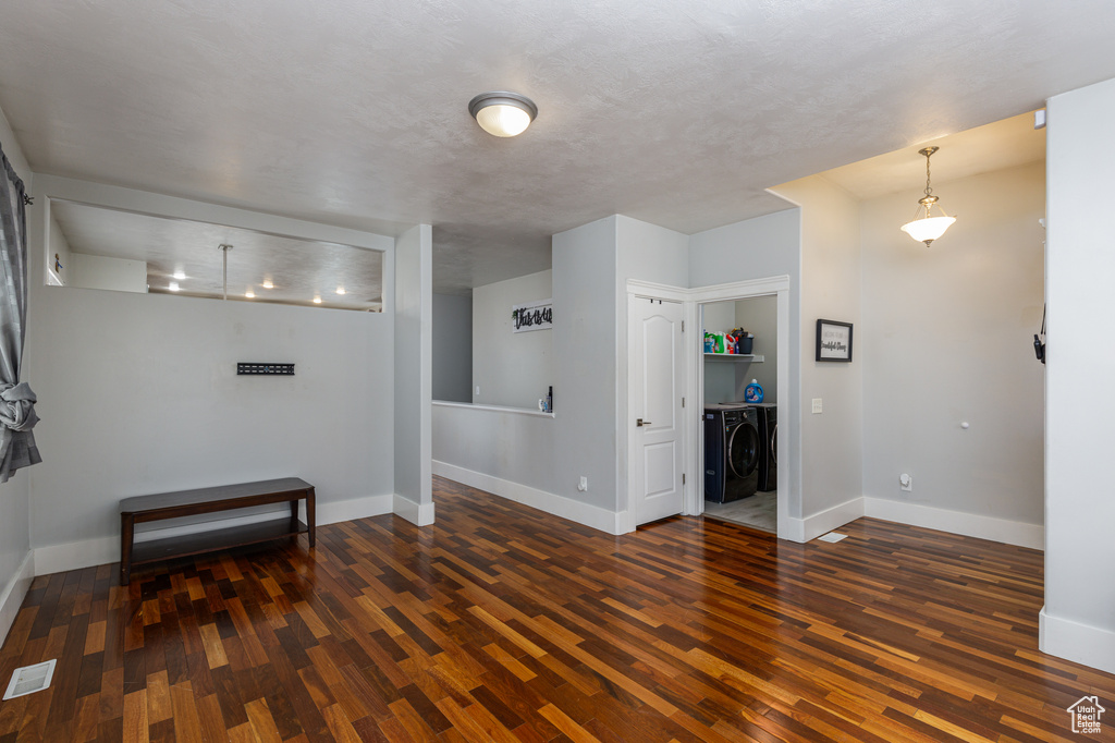 Empty room featuring dark hardwood / wood-style flooring and washer and dryer