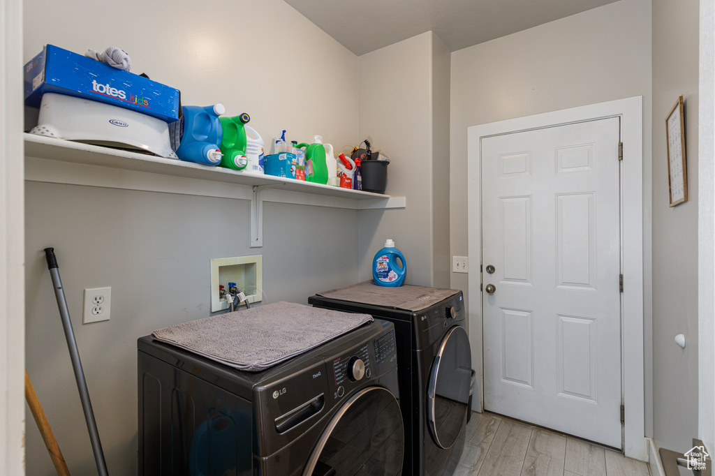 Washroom with washer and dryer, light hardwood / wood-style floors, and hookup for a washing machine