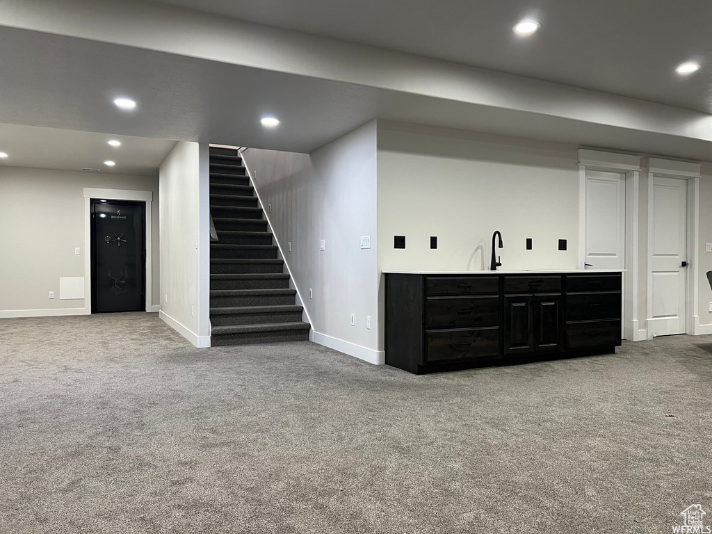 Basement with light carpet and sink