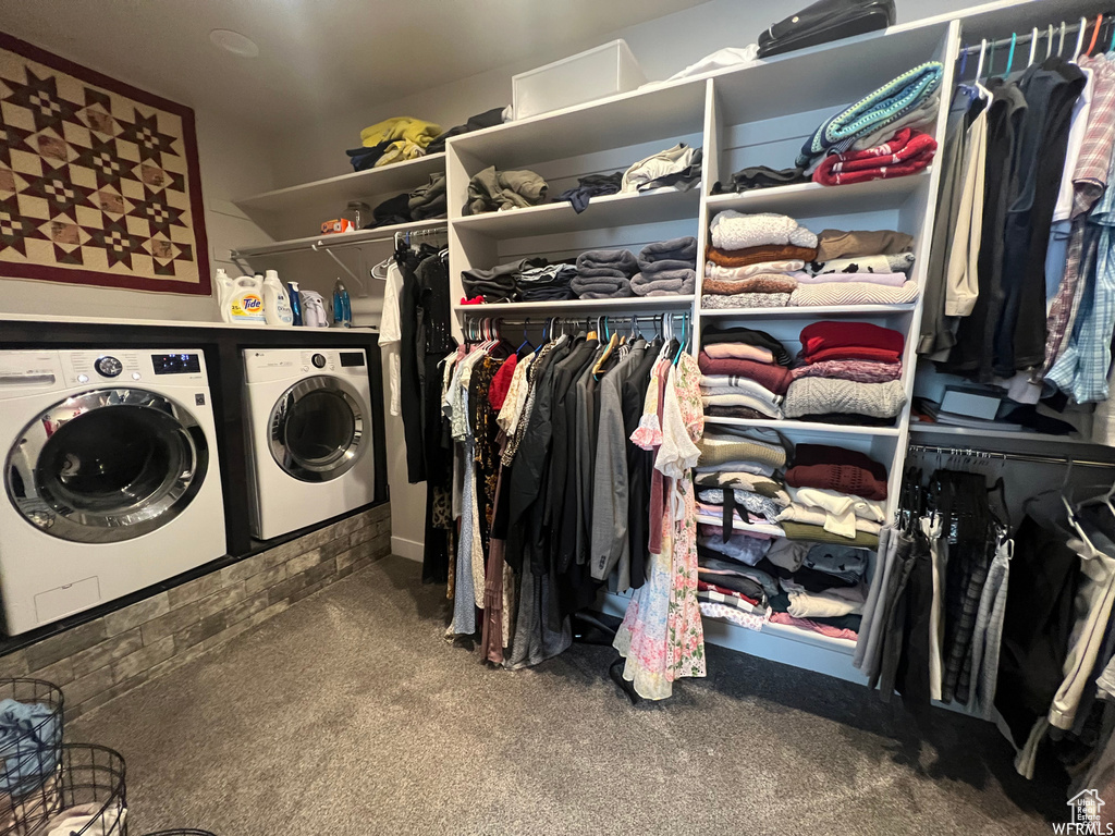 Walk in closet with washer and dryer and dark carpet