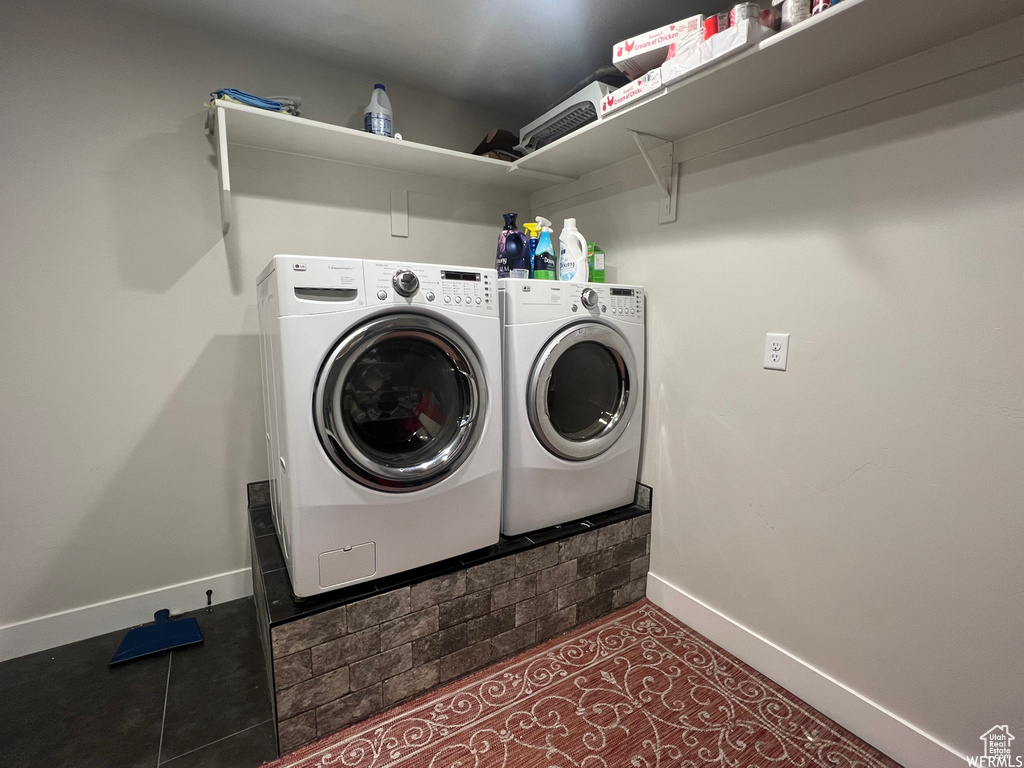 Laundry room with washing machine and dryer and dark tile floors
