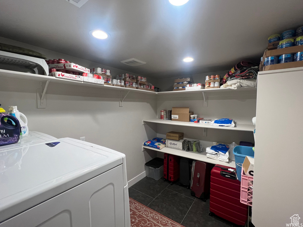Laundry area with dark tile flooring and washer and dryer
