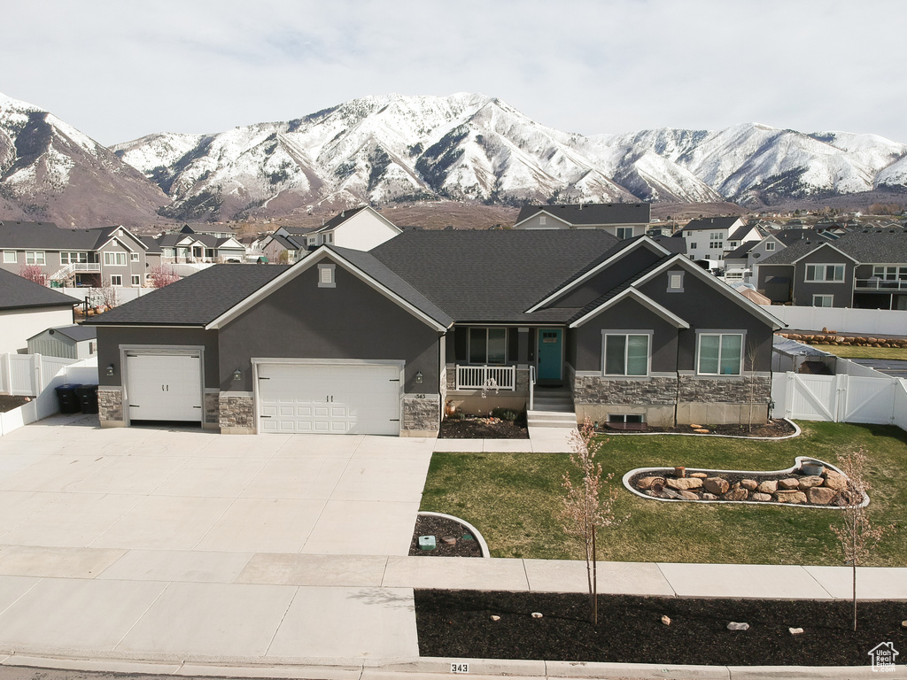 Craftsman-style house with a front yard, a mountain view, covered porch, and a garage