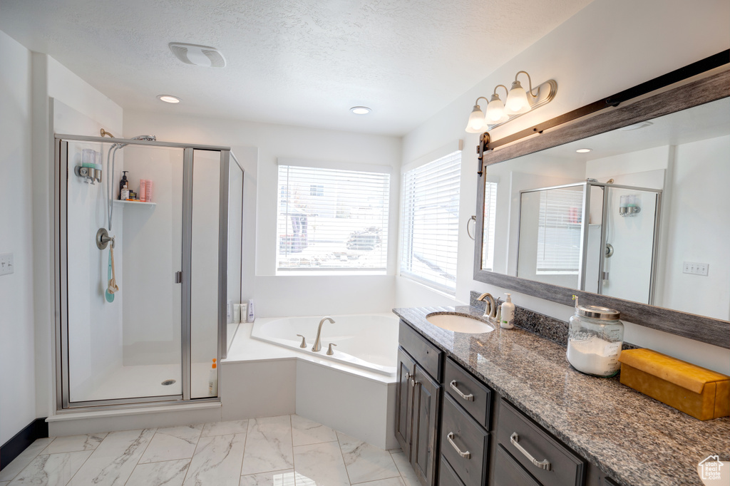 Bathroom featuring separate shower and tub, tile floors, large vanity, and a textured ceiling