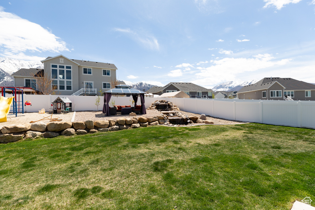 View of yard with a playground, a gazebo, and a mountain view