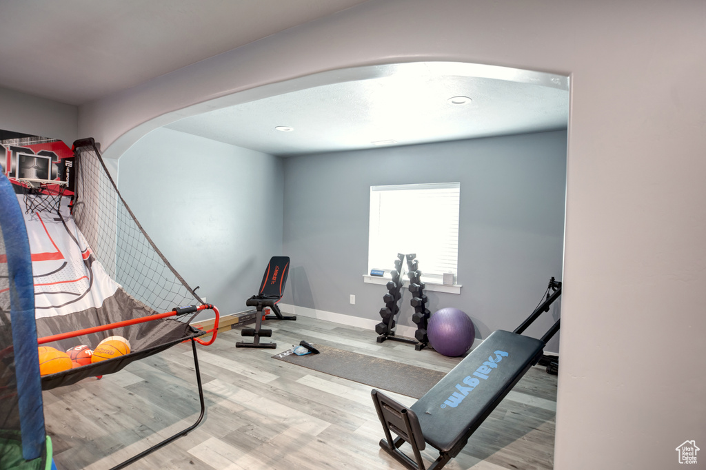 Exercise room with light hardwood / wood-style flooring