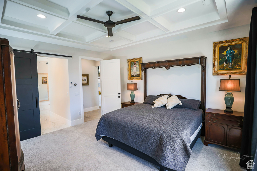 Bedroom with a barn door, coffered ceiling, ceiling fan, and beam ceiling