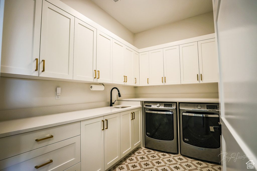 Washroom with cabinets, independent washer and dryer, sink, and light tile floors