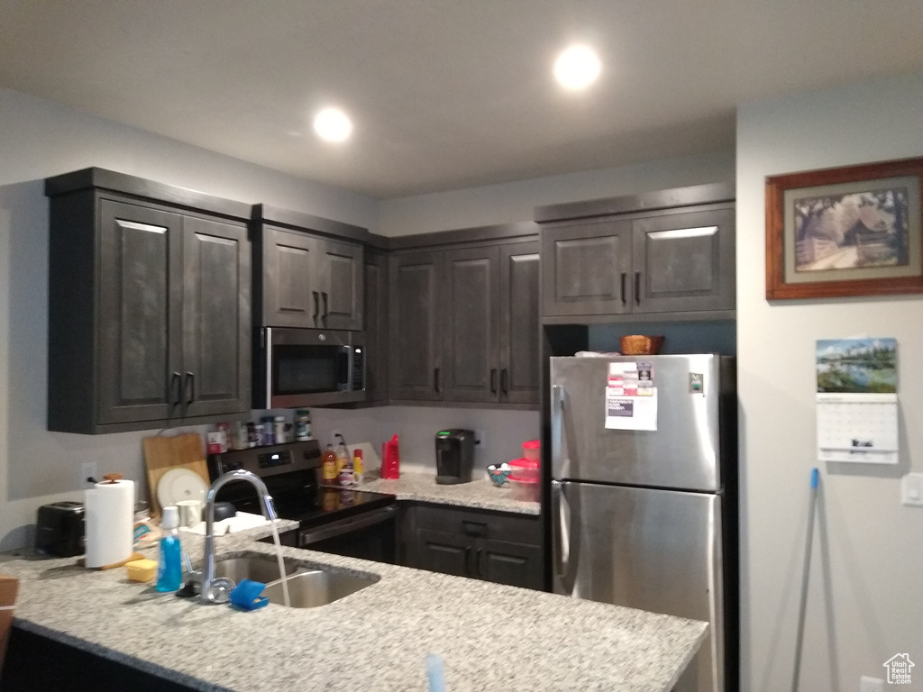 Kitchen featuring dark brown cabinets, appliances with stainless steel finishes, and sink
