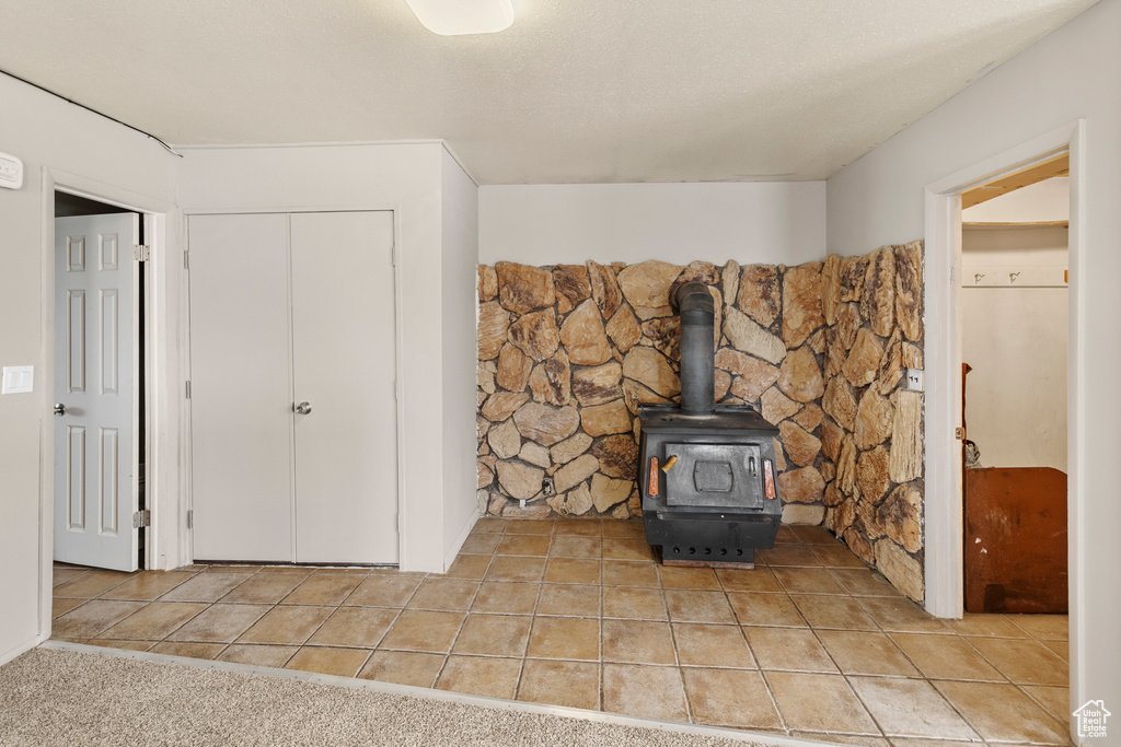 Interior details featuring light carpet and a wood stove