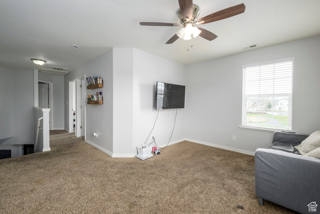Living area with ceiling fan and dark colored carpet