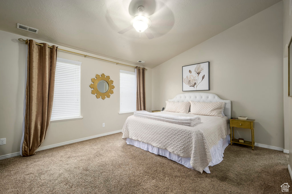 Bedroom with vaulted ceiling, ceiling fan, and dark carpet