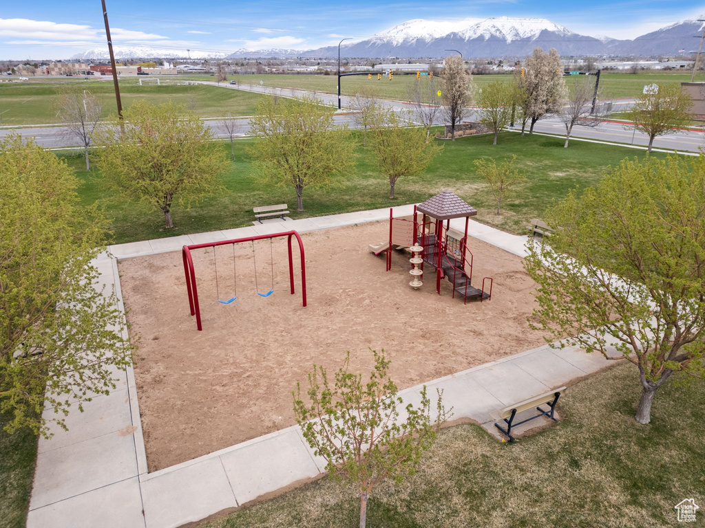 View of nearby features with a playground, a mountain view, and a yard