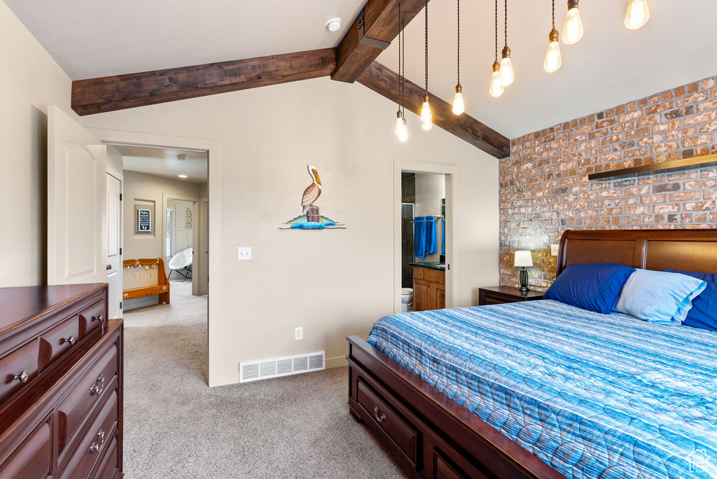 Carpeted bedroom featuring brick wall, ensuite bath, and lofted ceiling with beams