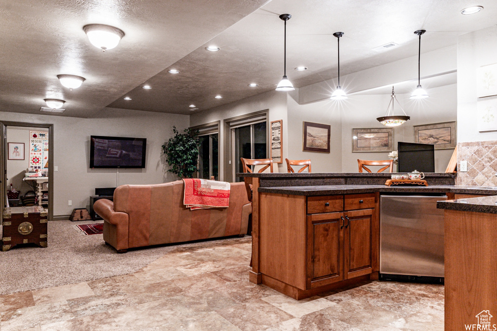 Kitchen with light carpet, stainless steel dishwasher, a center island, and pendant lighting