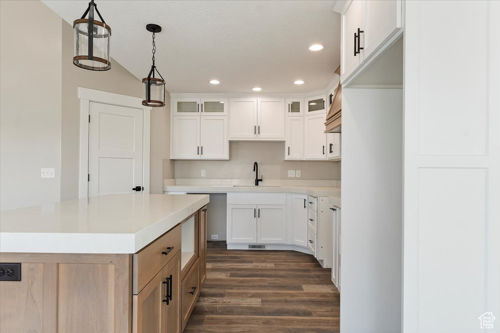 Kitchen with dark hardwood / wood-style flooring, pendant lighting, and white cabinets