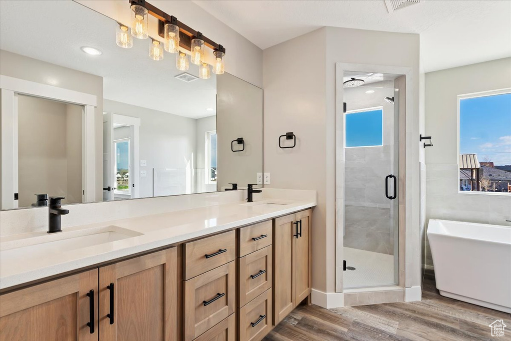 Bathroom with double sink, large vanity, an enclosed shower, and a healthy amount of sunlight