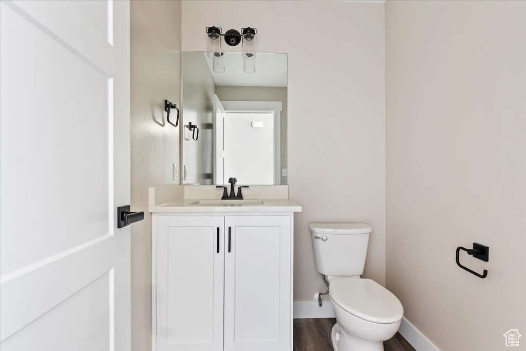 Bathroom featuring toilet, hardwood / wood-style flooring, and vanity