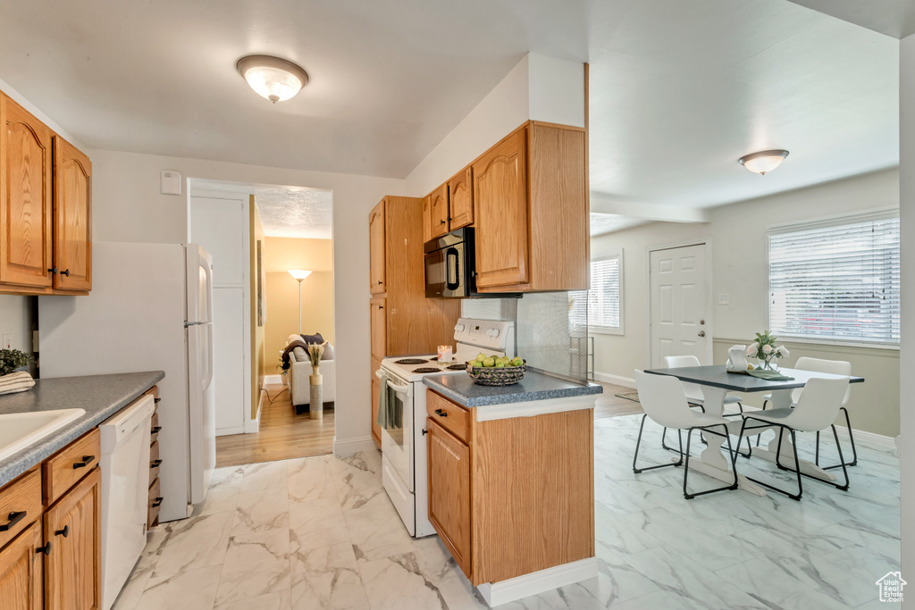 Kitchen with light tile floors, tasteful backsplash, and white appliances
