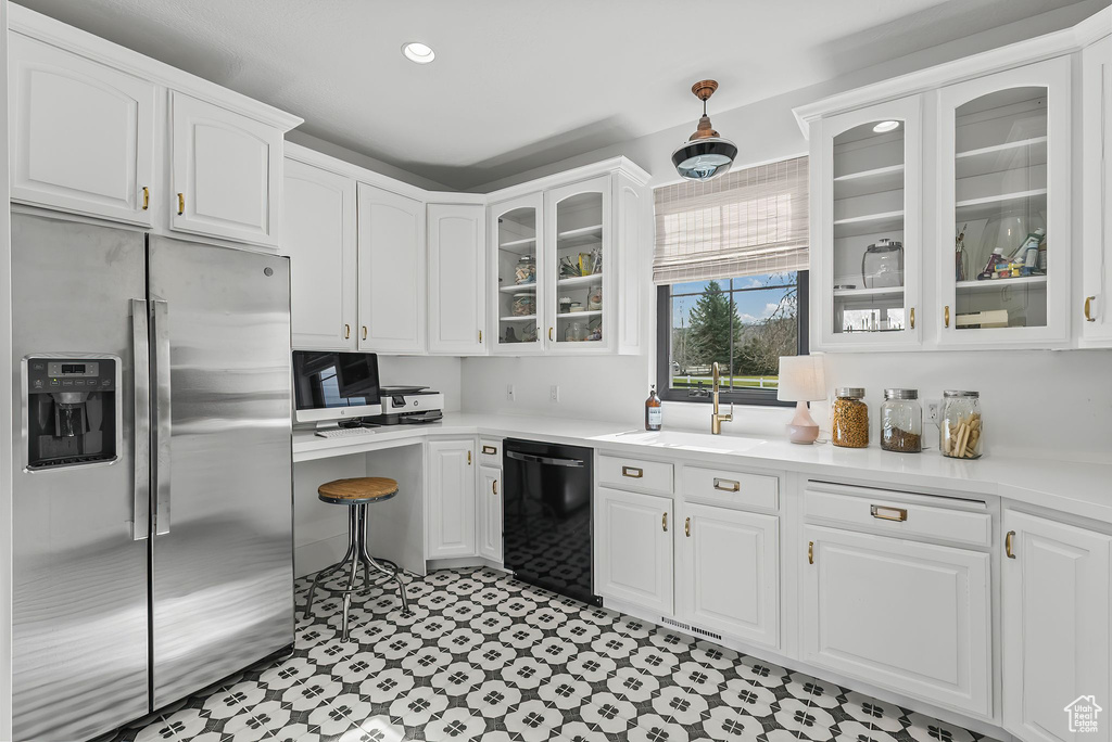 Kitchen with sink, white cabinets, stainless steel refrigerator with ice dispenser, and black dishwasher