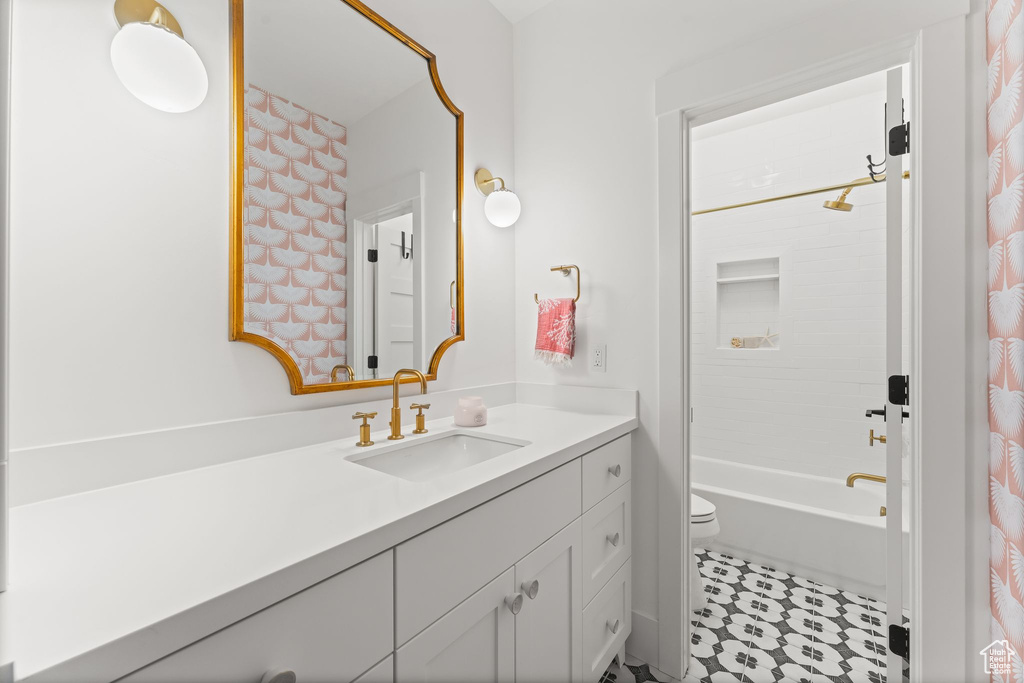 Full bathroom with large vanity, shower / bath combo, toilet, and tile flooring