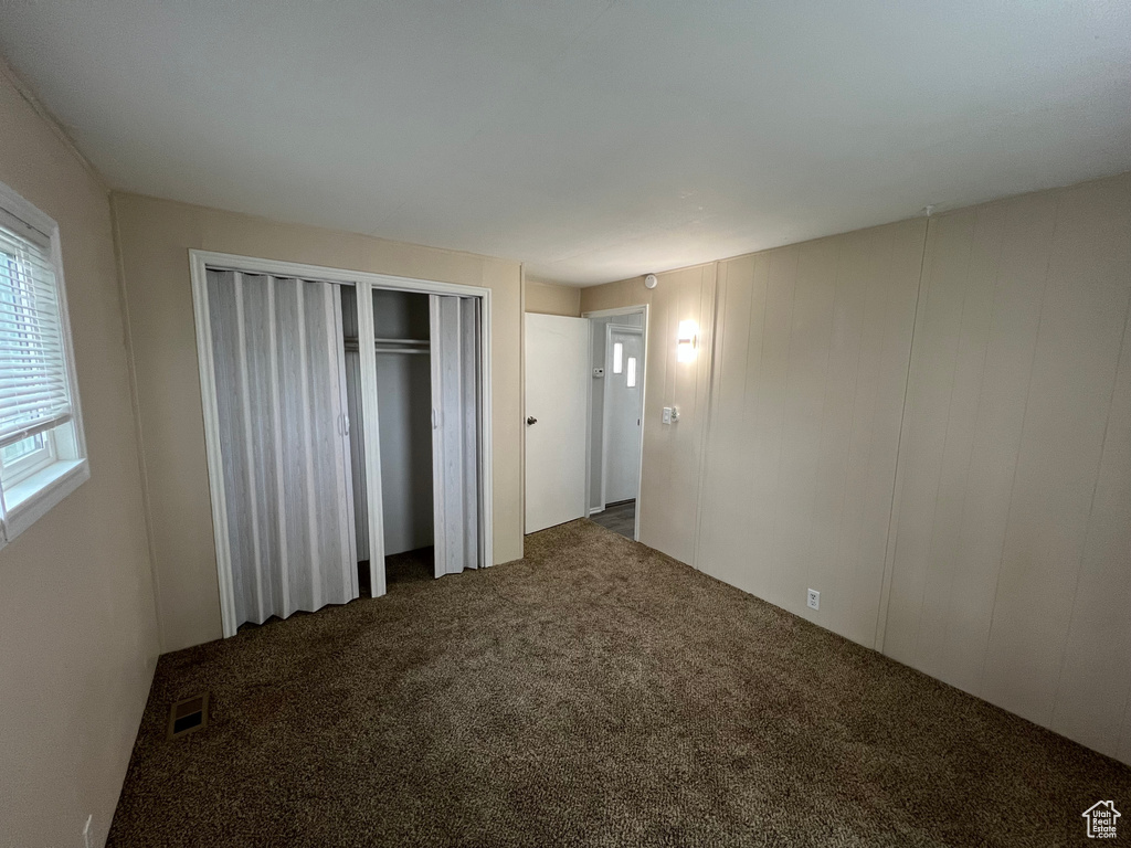 Unfurnished bedroom featuring dark colored carpet