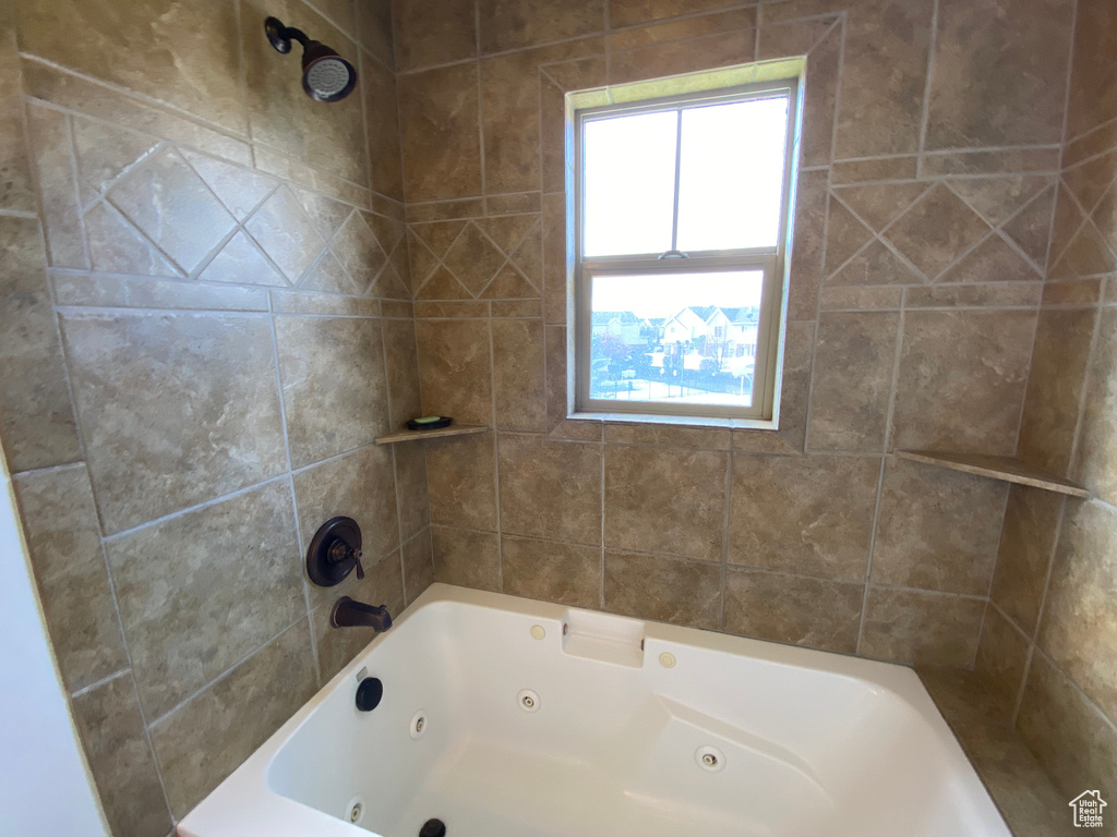 Bathroom with tiled shower / bath combo and a healthy amount of sunlight