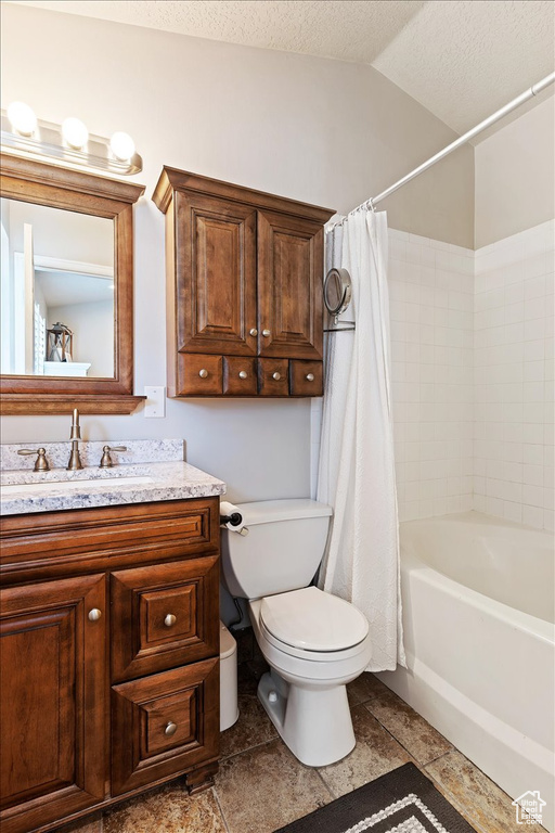 Full bathroom with toilet, shower / bath combo with shower curtain, a textured ceiling, vanity, and tile flooring