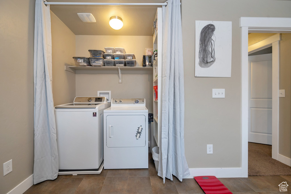 Laundry room with washing machine and dryer, dark tile floors, and hookup for a washing machine
