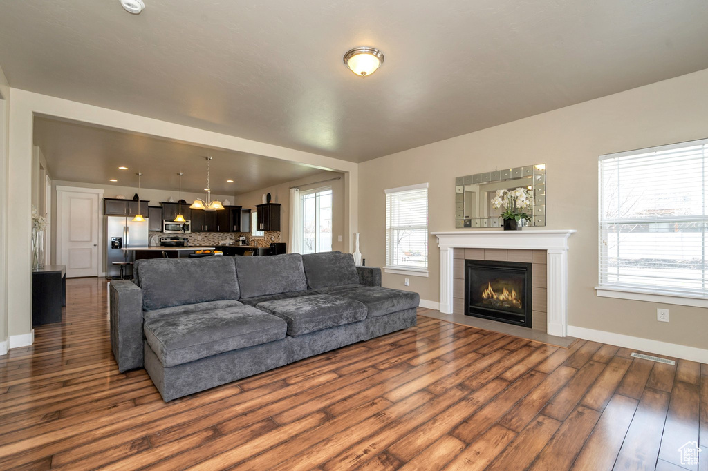 Living room with dark hardwood / wood-style floors and a tile fireplace