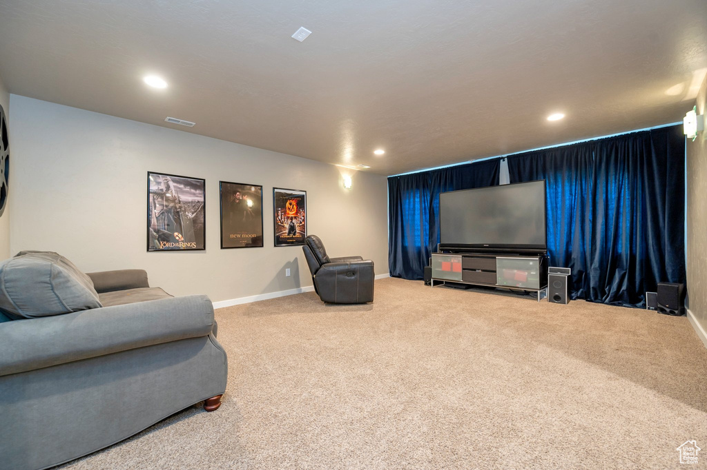 Home theater room featuring light carpet