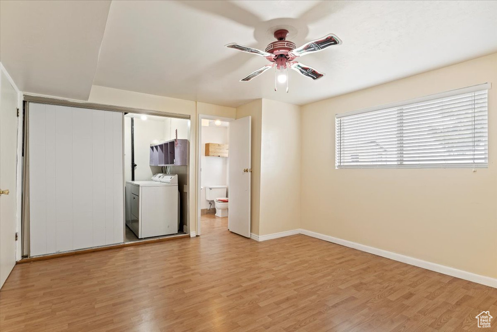 Spare room with light hardwood / wood-style floors, ceiling fan, and washer / dryer
