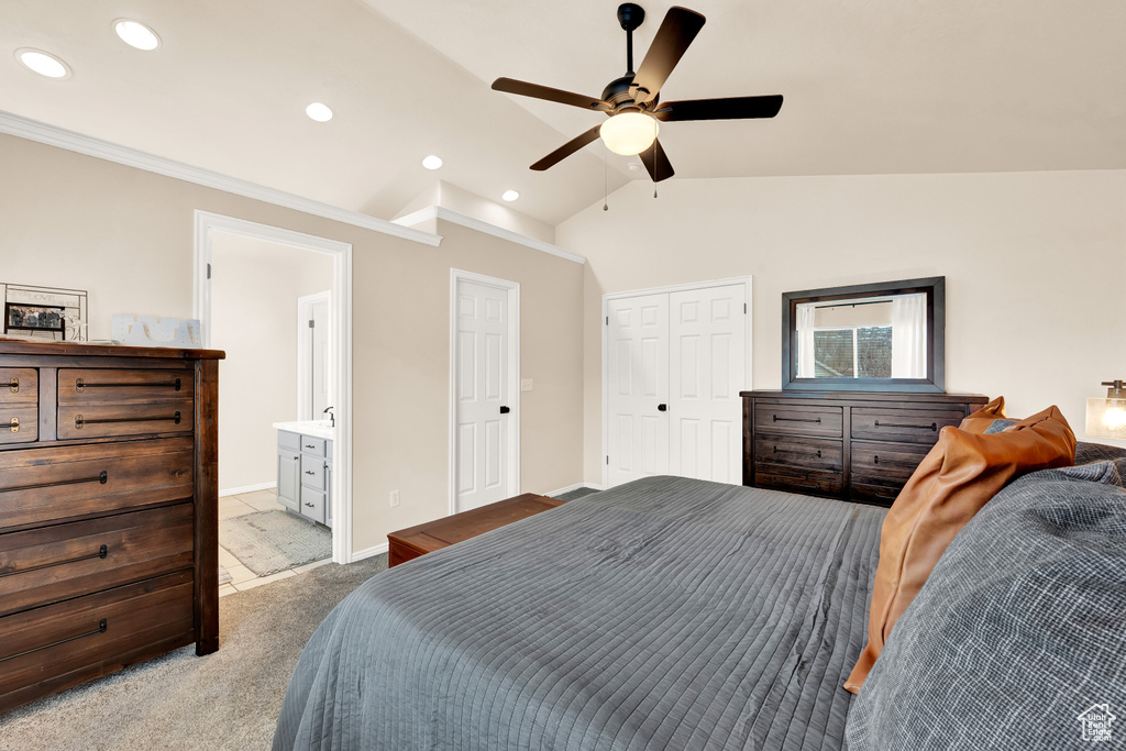 Bedroom featuring ceiling fan, light colored carpet, ensuite bath, and vaulted ceiling