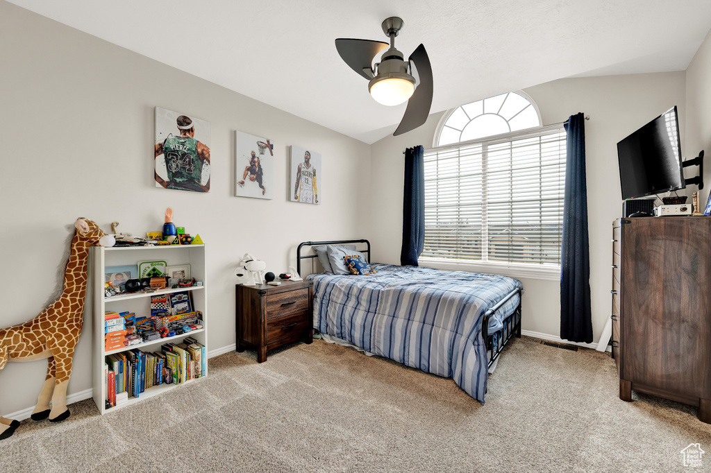 Bedroom with ceiling fan, lofted ceiling, and light colored carpet