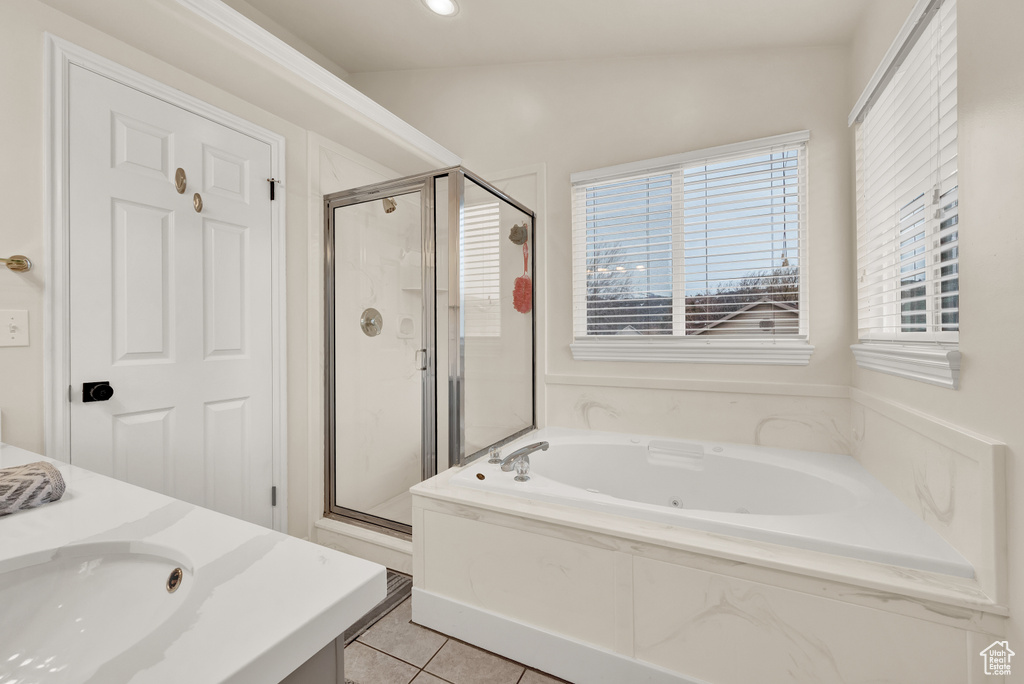 Bathroom featuring tile floors, vaulted ceiling, plus walk in shower, and sink