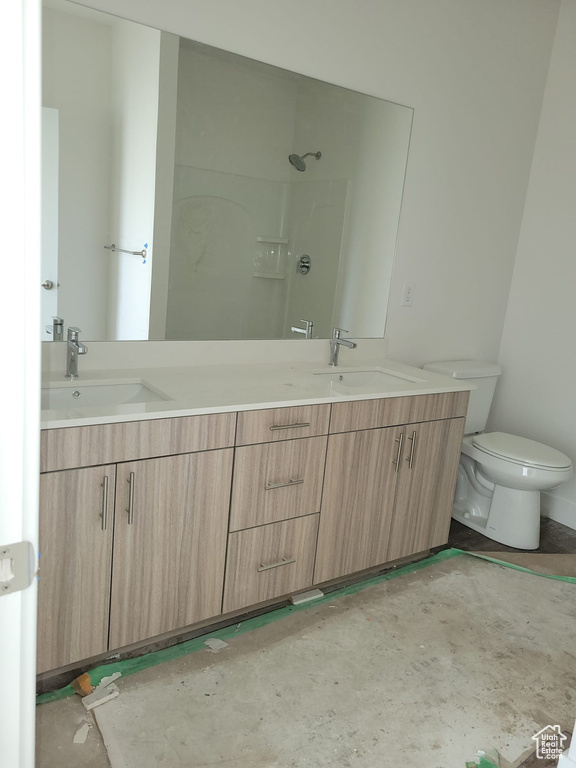 Bathroom featuring double vanity and toilet