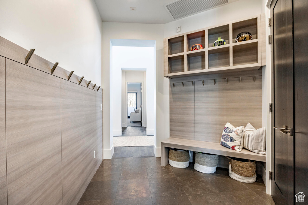 Mudroom with dark tile flooring and tile walls
