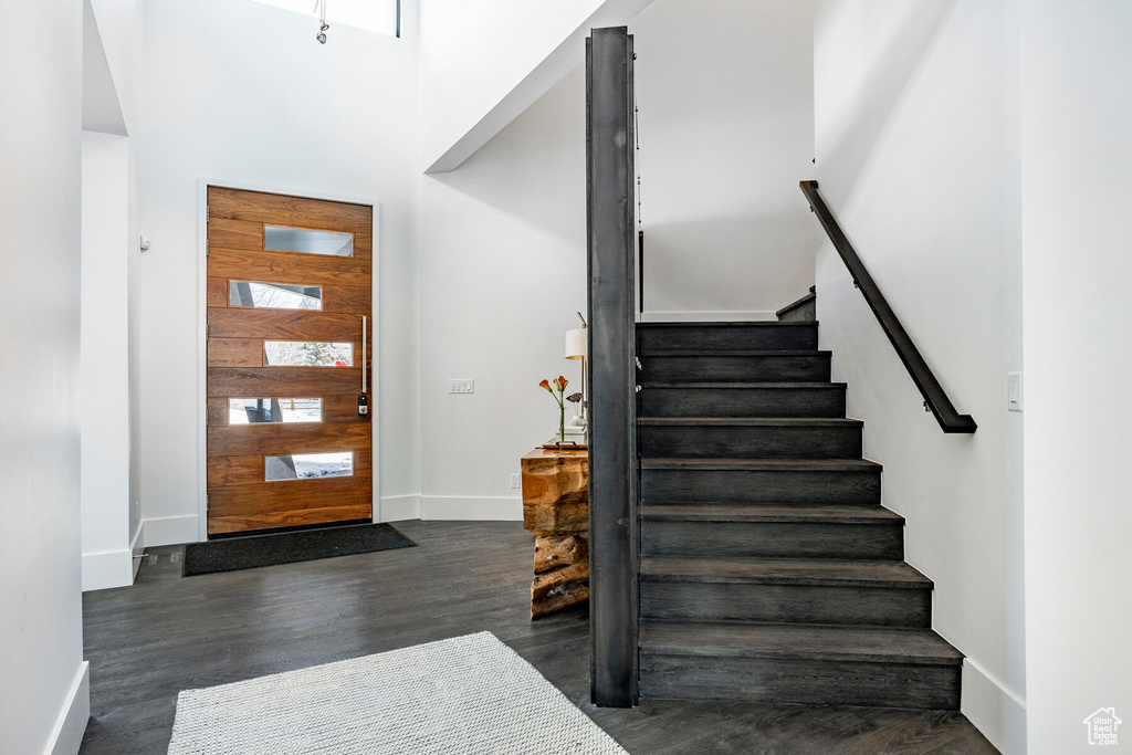 Foyer featuring dark hardwood / wood-style flooring and a towering ceiling