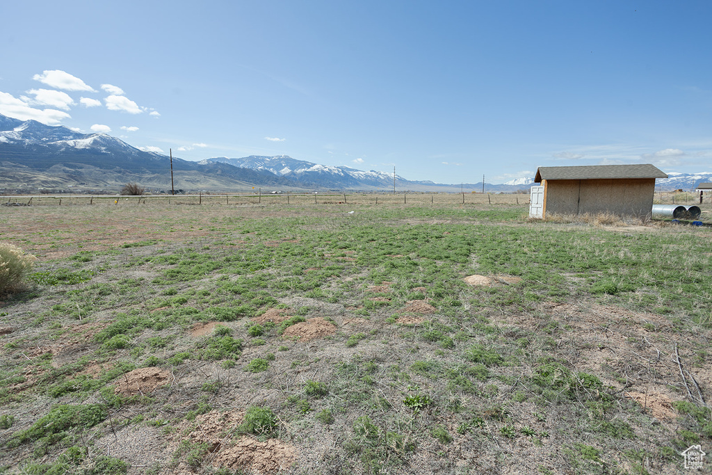Exterior space with a rural view, a shed, and a mountain view