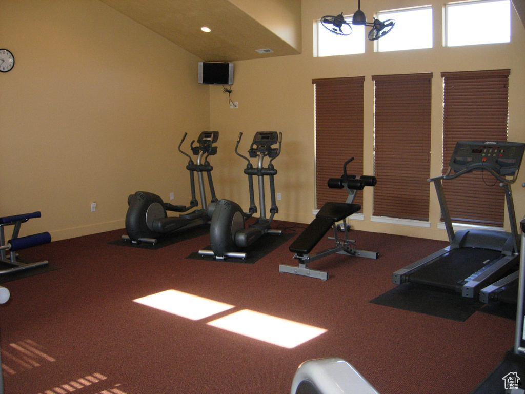 Workout room featuring carpet flooring and a chandelier