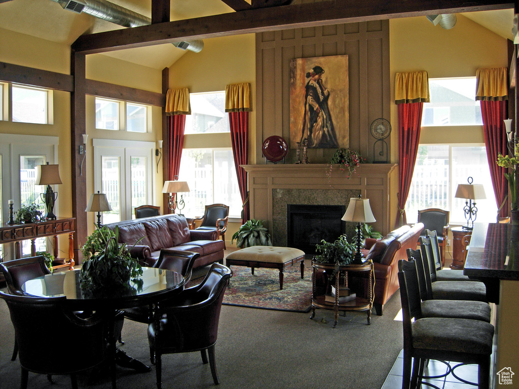 Living room with beam ceiling, a wealth of natural light, high vaulted ceiling, and french doors