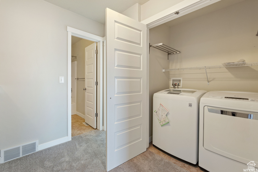 Laundry area with light colored carpet, washer hookup, and washer and dryer